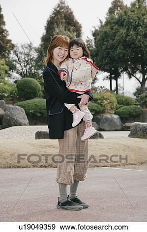 Mother carrying her daughter View Large Photo Image Stock Photo - Mother carrying her daughter. Fotosearch