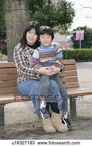 Stock Image - Portrait of mother and son sitting. Fotosearch