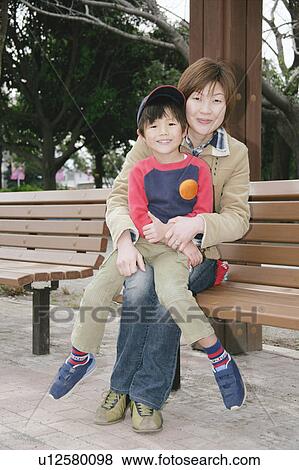 Stock Photo - Portrait of mother and son sitting. Fotosearch