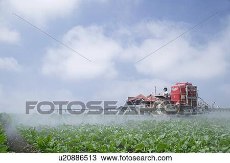 Stock Image - A farmer cultivating field. Fotosearch