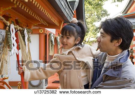 Stock Image - Father and daughter at shrine. Fotosearch