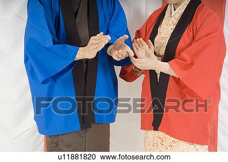 Stock Image - Man and woman clapping hands. Fotosearch