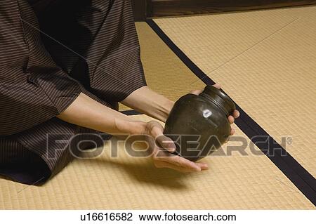 Stock Image - Man examining urn. Fotosearch