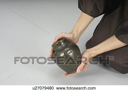 Man examining urn View Large Photo Image Stock Image - Man examining urn. Fotosearch