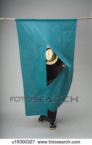 Stock Photo - Man pushing past curtain. Fotosearch