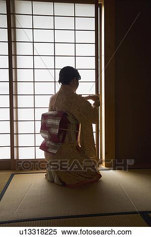 Stock Photography - Woman opening shoji door. Fotosearch