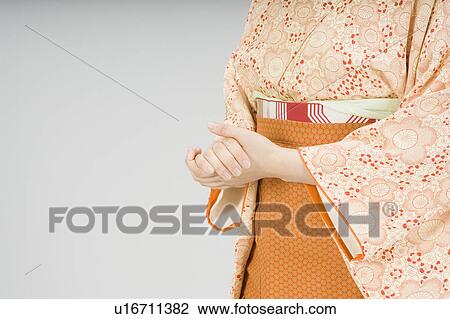 Stock Image - Woman rubbing her hands together. Fotosearch