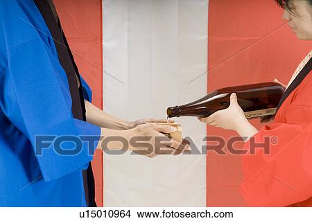 Picture - Woman serving sake. Fotosearch