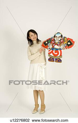 Stock Image - Young woman holding kite. Fotosearch