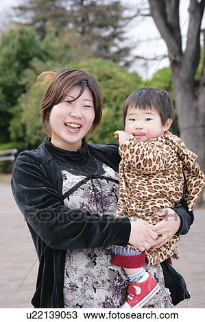 Stock Image - Mother carrying baby. Fotosearch