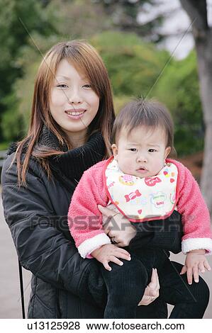 Mother carrying baby View Large Photo Image Stock Photo - Mother carrying baby. Fotosearch