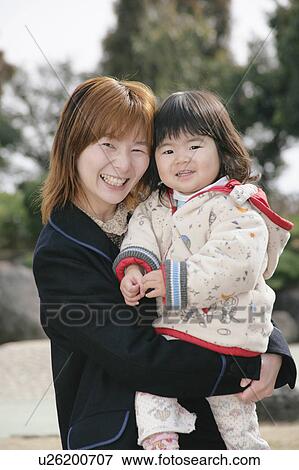 Stock Photo - Mother carrying her daughter. Fotosearch