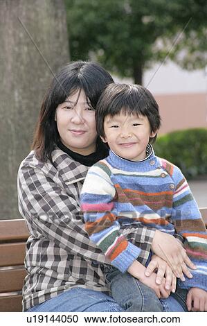 Stock Image - Portrait of mother and son sitting. Fotosearch