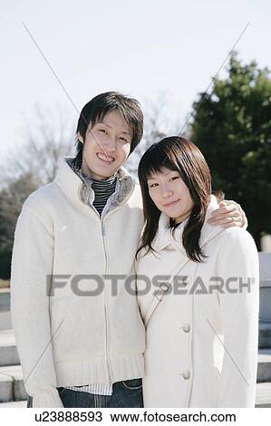 Stock Image - Portrait of young couple standing. Fotosearch