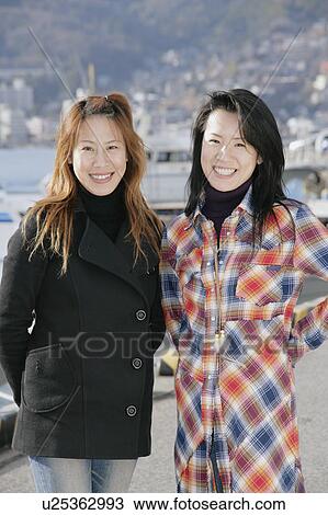 Stock Image - Portrait of young women standing. Fotosearch