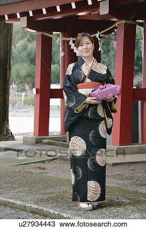 Stock Image - Mid adult woman wearing kimono. Fotosearch