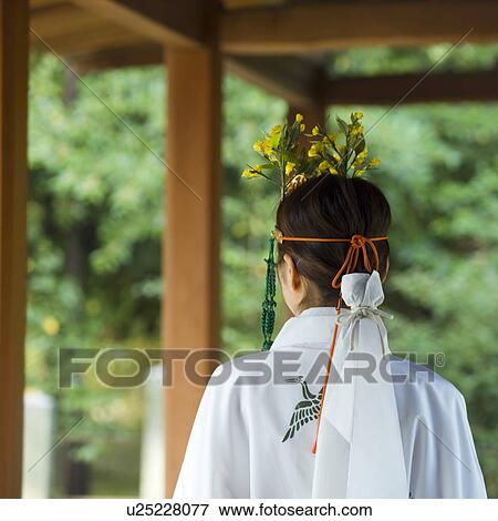 Stock Photo - Rear view of female attendant walking at shrine. Fotosearch