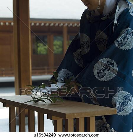 Shinto priest placing plant at altar View Large Photo Image Stock Photo - Shinto priest placing plant at altar. Fotosearch
