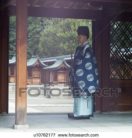 Stock Photo - Shinto priest standing at shrine. Fotosearch