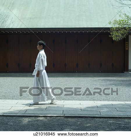 Stock Photography - Shinto priest walking at shrine. Fotosearch