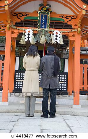Stock Photo - Couple praying at shrine. Fotosearch