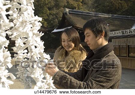 Stock Photograph - Couple tying fortune paper. Fotosearch