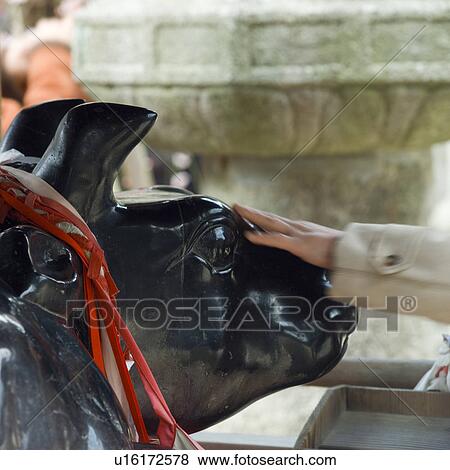 Hand of a woman touching statue at shrine View Large Photo Image Stock Photo - Hand of a woman touching statue at shrine. Fotosearch