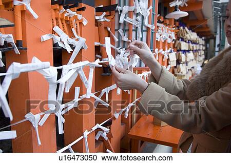 Young woman tying fortune paper View Large Photo Image Stock Image - Young woman tying fortune paper. Fotosearch