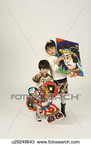 Stock Image - Brother and sister holding kites. Fotosearch