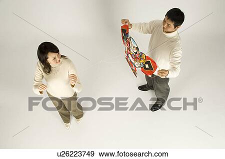 Stock Photo - Couple holding kite. Fotosearch