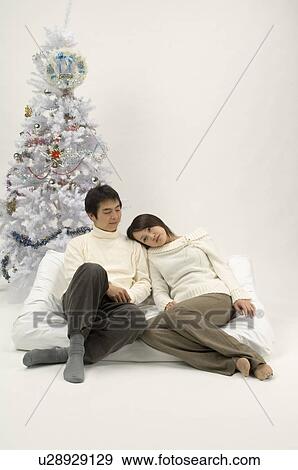 Stock Photo - Couple sitting on sofa. Fotosearch