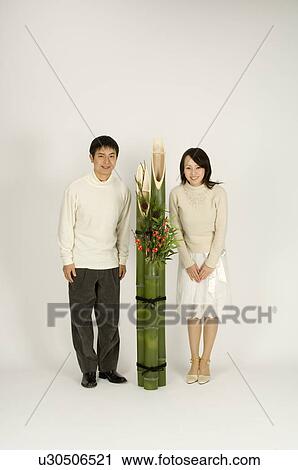 Couple standing next to kadomatsu View Large Photo Image Stock Image - Couple standing next to kadomatsu. Fotosearch