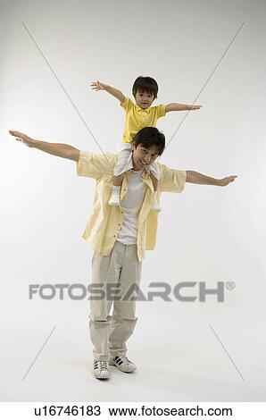 Stock Image - Father carrying son on shoulders. Fotosearch