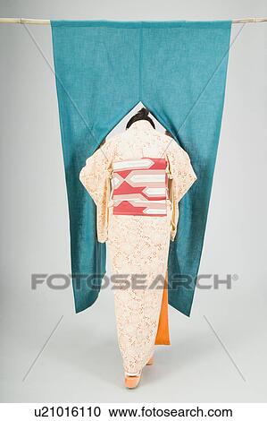 Stock Image - Woman pushing past curtain. Fotosearch