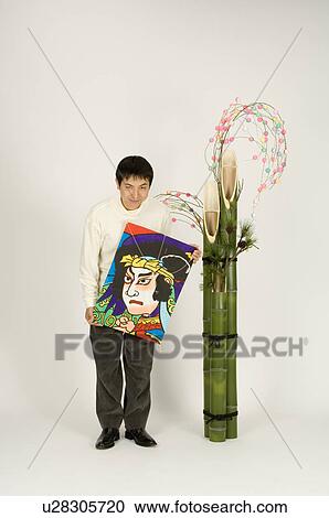 Stock Image - Young man and New Year decoration. Fotosearch