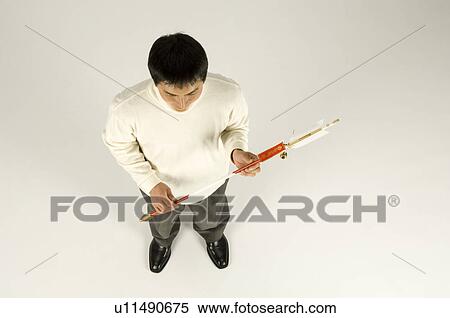 Stock Photography - Young man holding arrow. Fotosearch