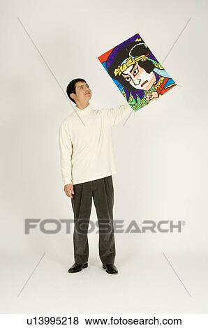 Young man holding kite View Large Photo Image Stock Photo - Young man holding kite. Fotosearch