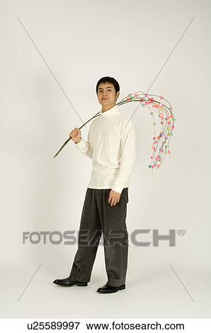 Young man holding New Year decoration View Large Photo Image Stock Photo - Young man holding New Year decoration. Fotosearch