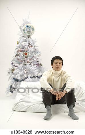 Young man spending Christmas alone View Large Photo Image Stock Photo - Young man spending Christmas alone. Fotosearch