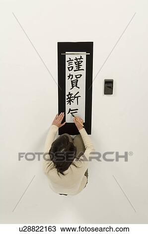 Stock Image - Young woman writing letters with ink brush. Fotosearch