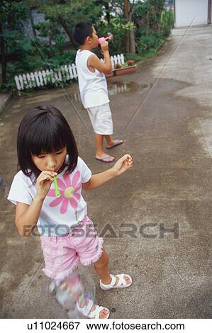 Boy and girl blowing bubbles View Large Photo Image Stock Photo - Boy and girl blowing bubbles. Fotosearch