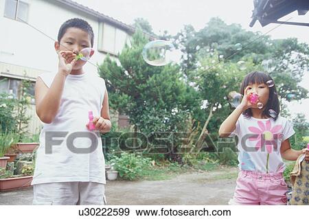 Boy and girl blowing bubbles View Large Photo Image Stock Photo - Boy and girl blowing bubbles. Fotosearch