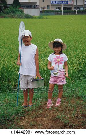Boy and girl standing in rice paddy View Large Photo Image Stock Photo - Boy and girl standing in rice paddy. Fotosearch