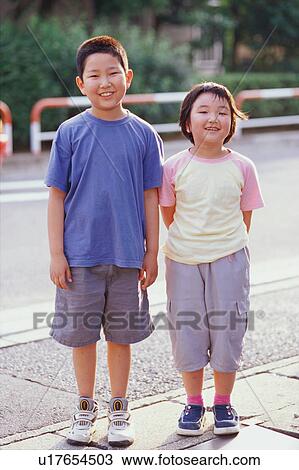 Boy and girl standing on sidewalk View Large Photo Image Stock Image - Boy and girl standing on sidewalk. Fotosearch