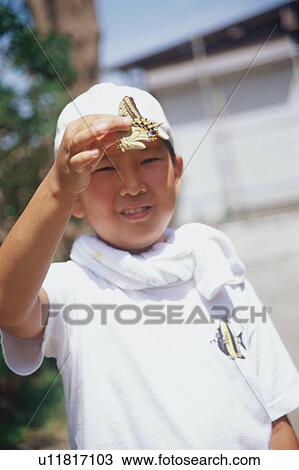 Stock Image - Boy holding butterfly. Fotosearch