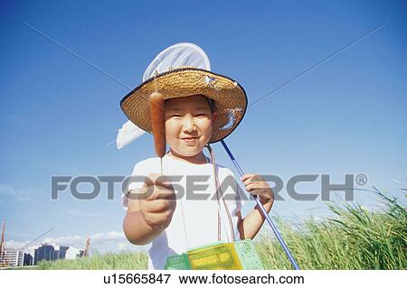 Stock Photo - Boy holding cattail. Fotosearch