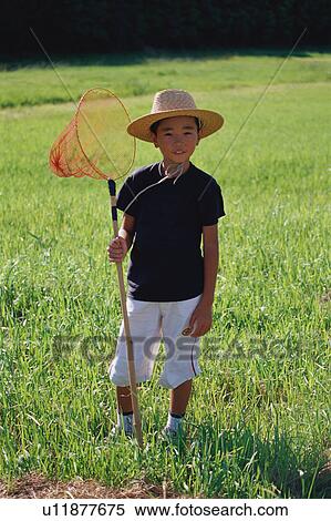 Boy standing in field with butterfly net View Large Photo Image Stock Photography - Boy standing in field with butterfly net. Fotosearch