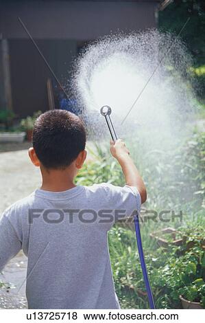 Stock Photo - Boy watering garden. Fotosearch