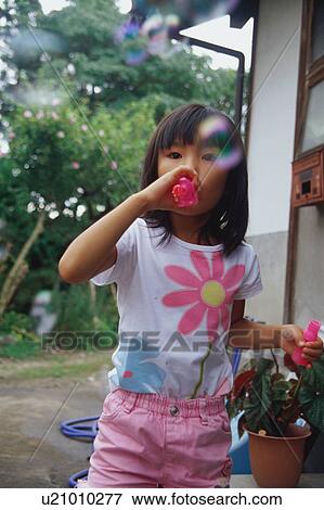 Girl blowing bubbles View Large Photo Image Stock Photo - Girl blowing bubbles. Fotosearch