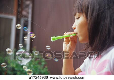 Stock Photograph - Girl blowing bubbles. Fotosearch